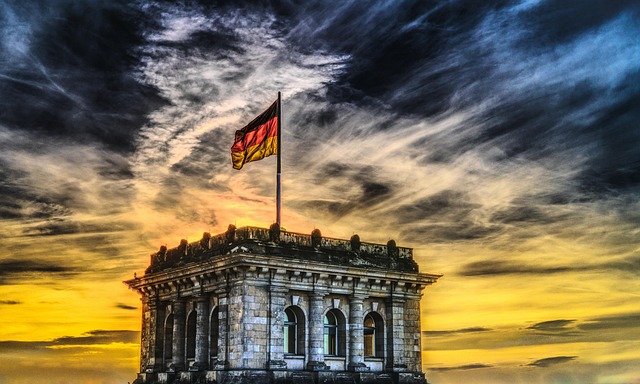 The German flag flying above the Reichstag building at dusk.