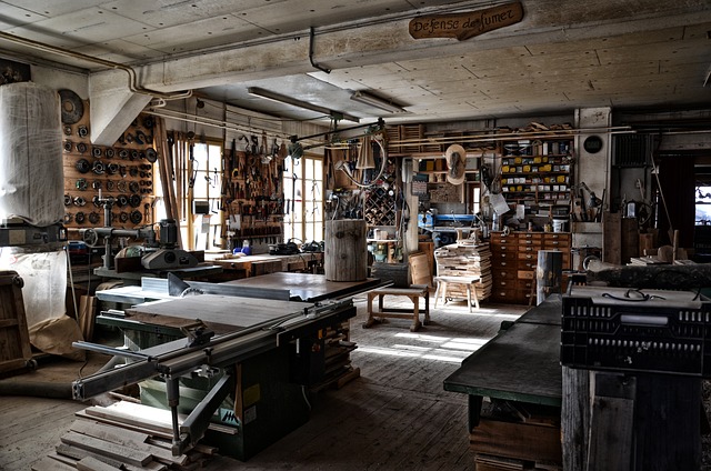 A working joinery workshop: a table saw, a wall of hand tools and daylight through the windows.